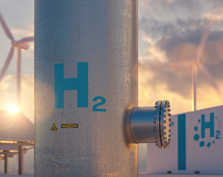A close-up of a hydrogen energy storage tank with windmills in the background