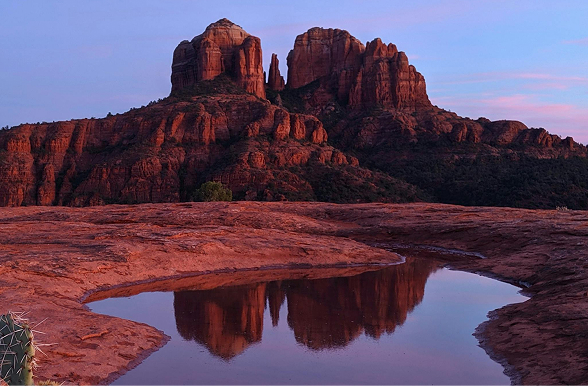 A desert landscape at sunset with river in foreground