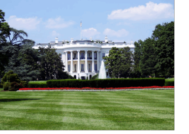 The White House with its front lawn, fountain, and garden on a sunny day.